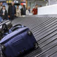 Blue luggage on the baggage claim carousel 