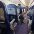 A crowded commercial airplane with people sitting in the seats.