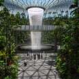 an indoor waterfall at an airport, with people 