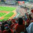 japanese man enjoying baseball game in a jersey and hat