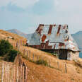 house with tin roof at entrance to lukomir bosnia