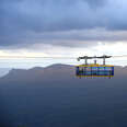 man standing on top of a cable car in the mountains of katoomba